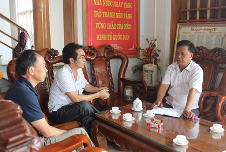 Ông Mai Xuân Thìn (bên phải) trao đổi thông tin sản xuất, kinh doanh với các xã viên trong HTX.